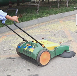 环卫工人使用手推式扫地机清扫马路